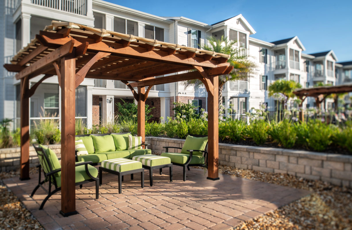 View of pergola covered lounge seating near swimming pool area