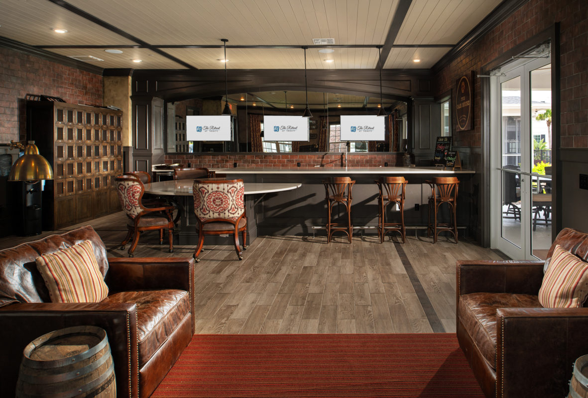 Alternate view of pub with three television screens, leather armchair seating, and barstools