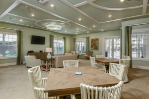 Clubroom with TV, couches, and card table seating