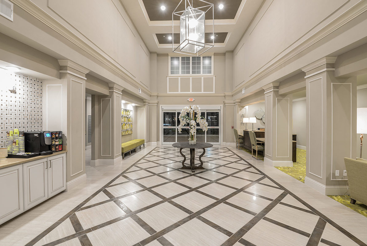 Leasing office interior with coffee bar, lounge seating, and leasing desks